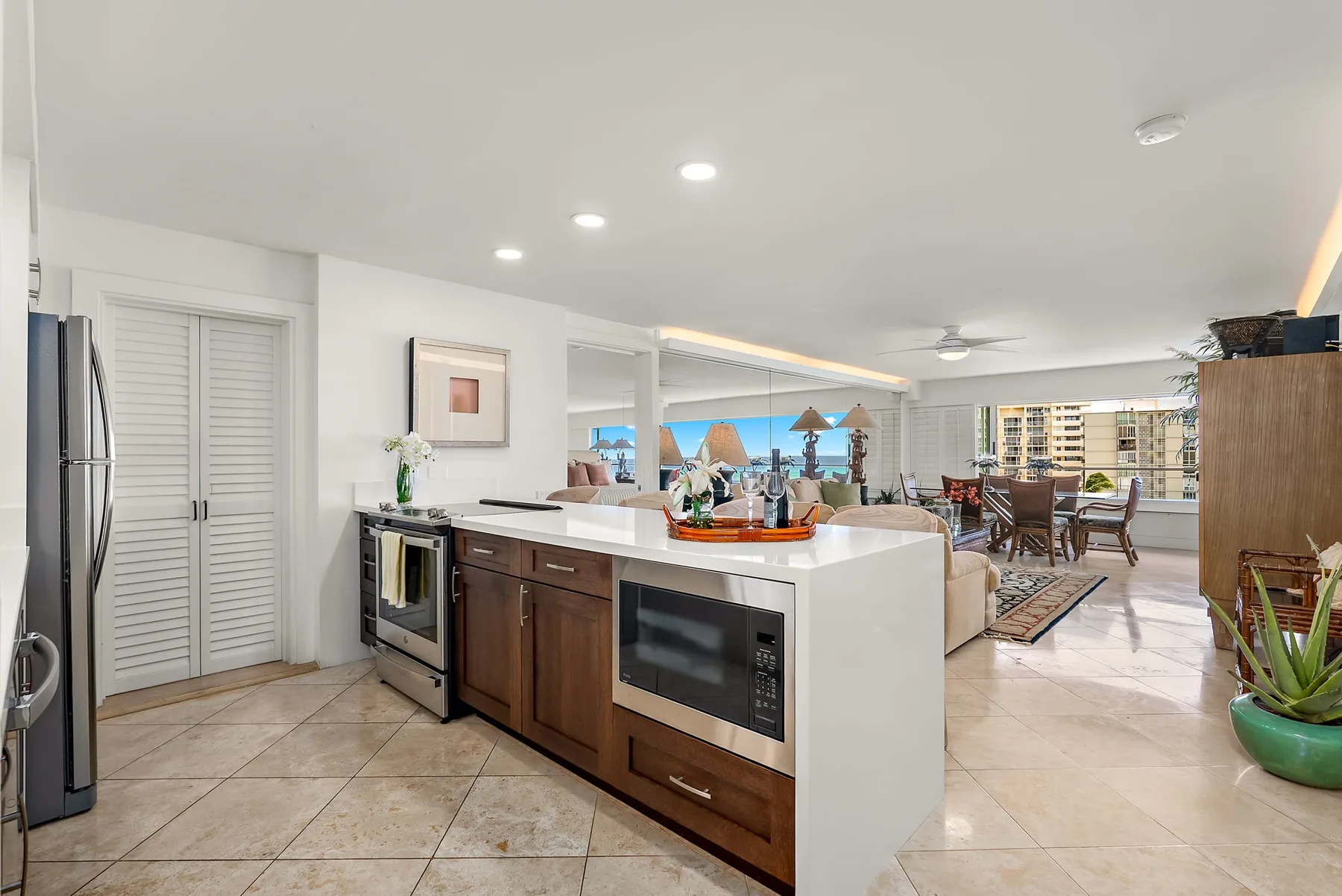 Una cocina abierta y zona de comedor con una isla central y una mesa junto a las ventanas.