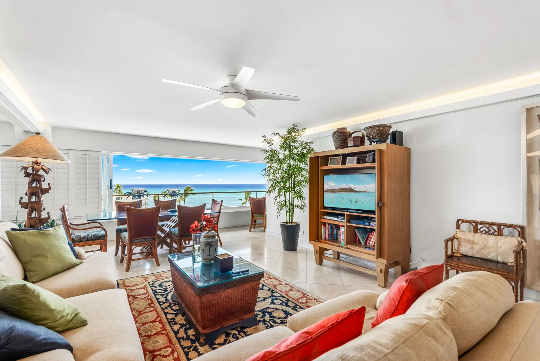 Una sala luminosa con asientos, una mesa de centro y una amplia vista al mar.