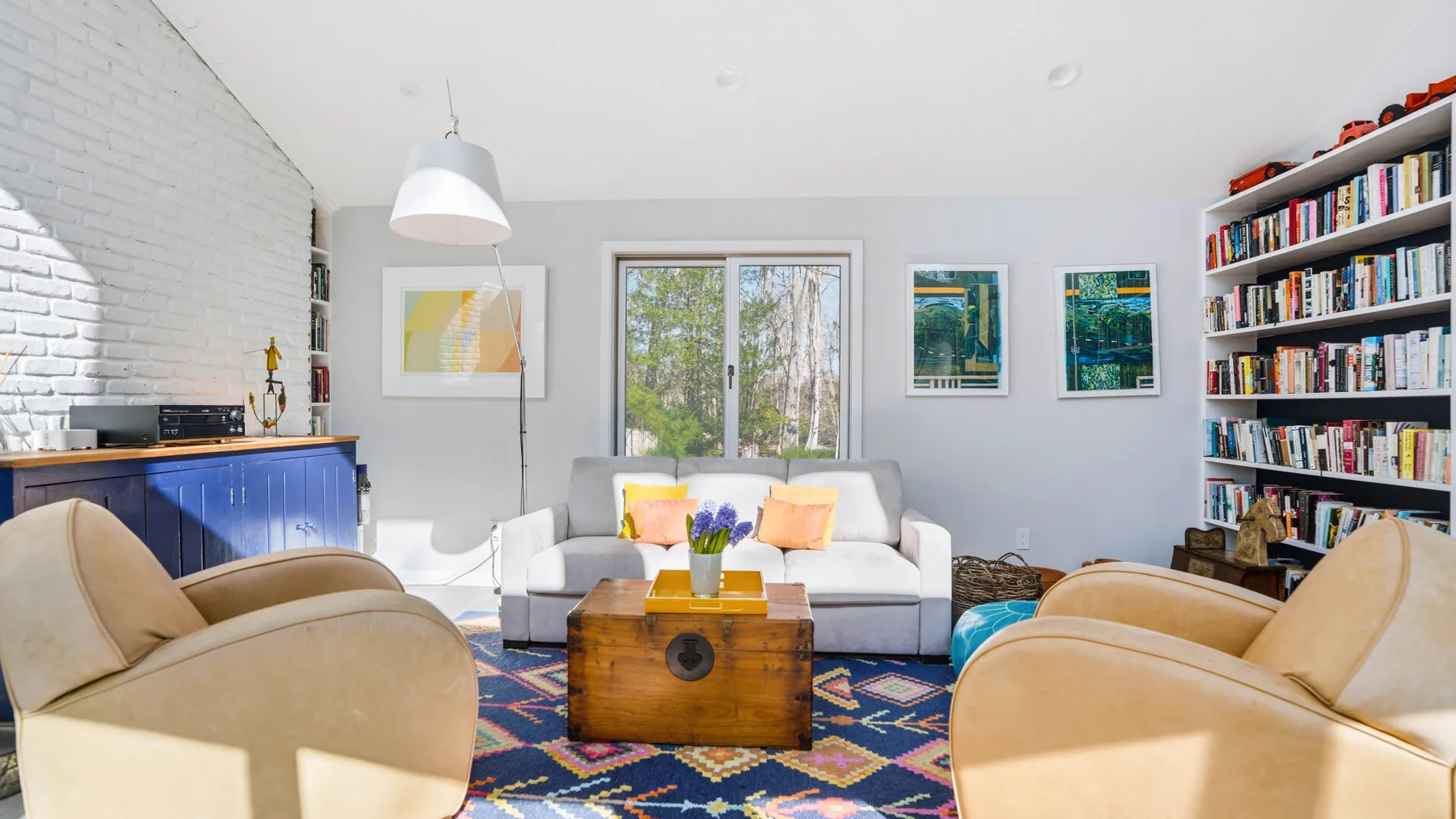 A bright living room with seating around a wooden coffee table.