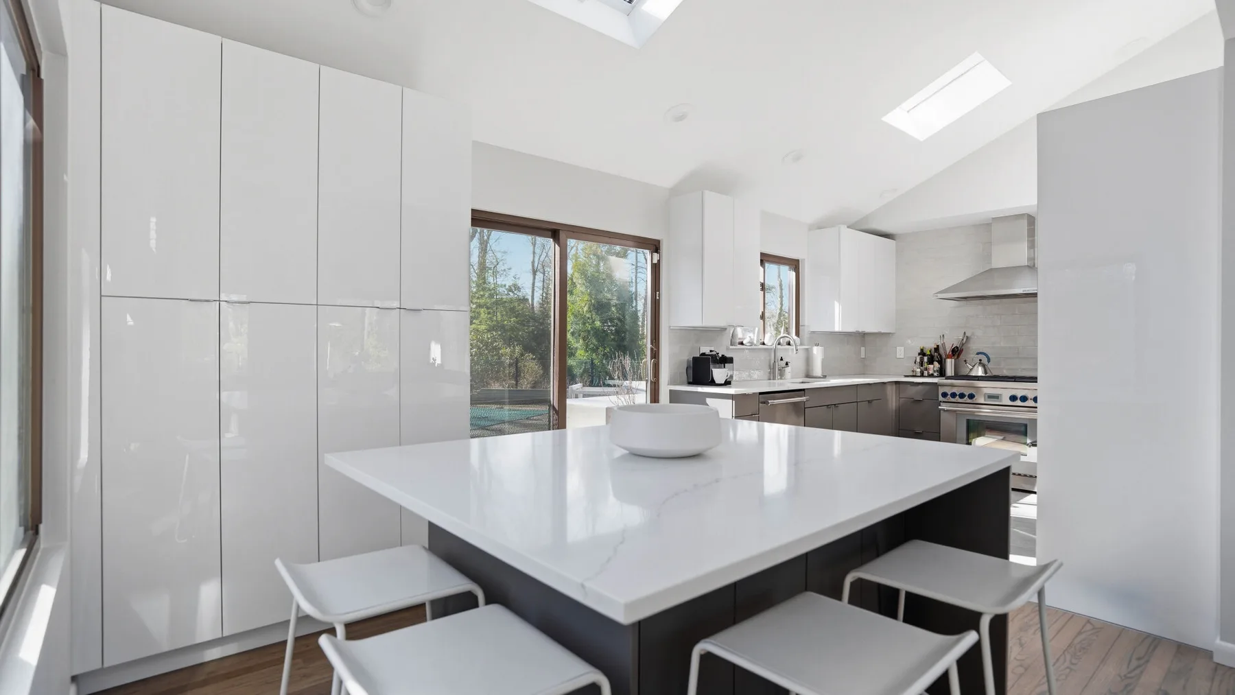 A bright modern kitchen with a large island and surrounding cabinets.