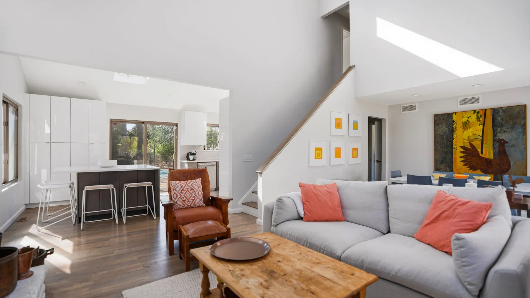 A bright open-plan living and dining area with a gray sectional sofa.
