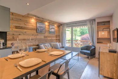 Un comedor y sala de estar con una mesa larga y puertas corredizas de vidrio.