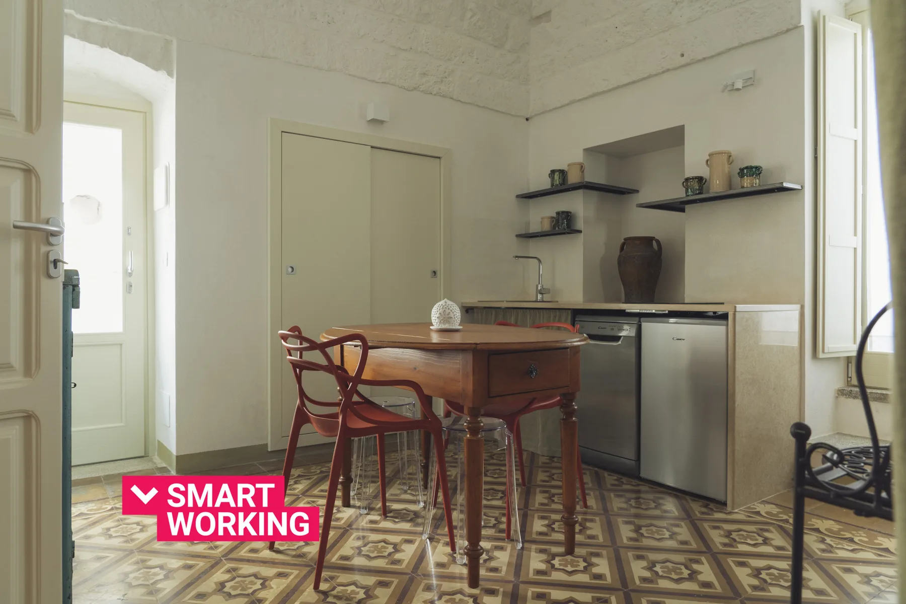 Un comedor con una mesa de madera y sillas junto a una cocina compacta.