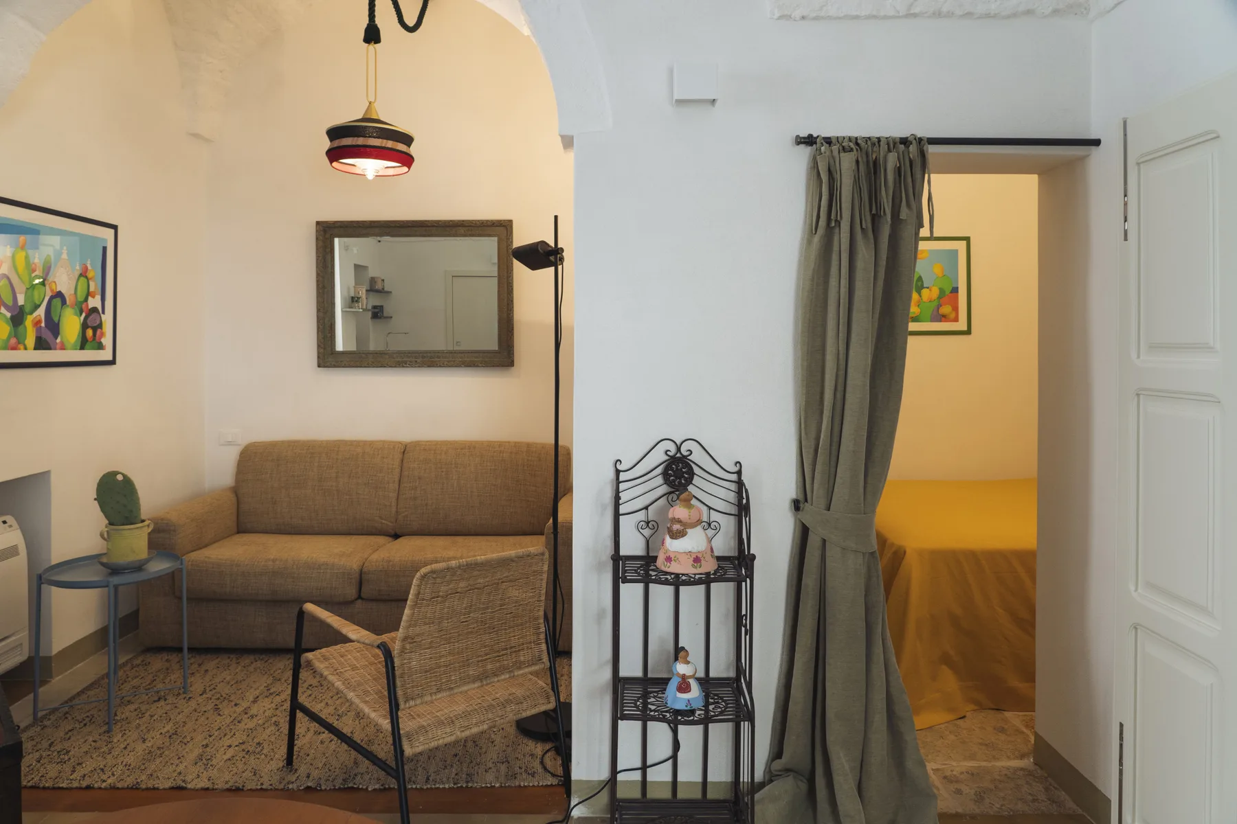 Una sala de estar con asientos junto a la entrada abierta de un dormitorio.