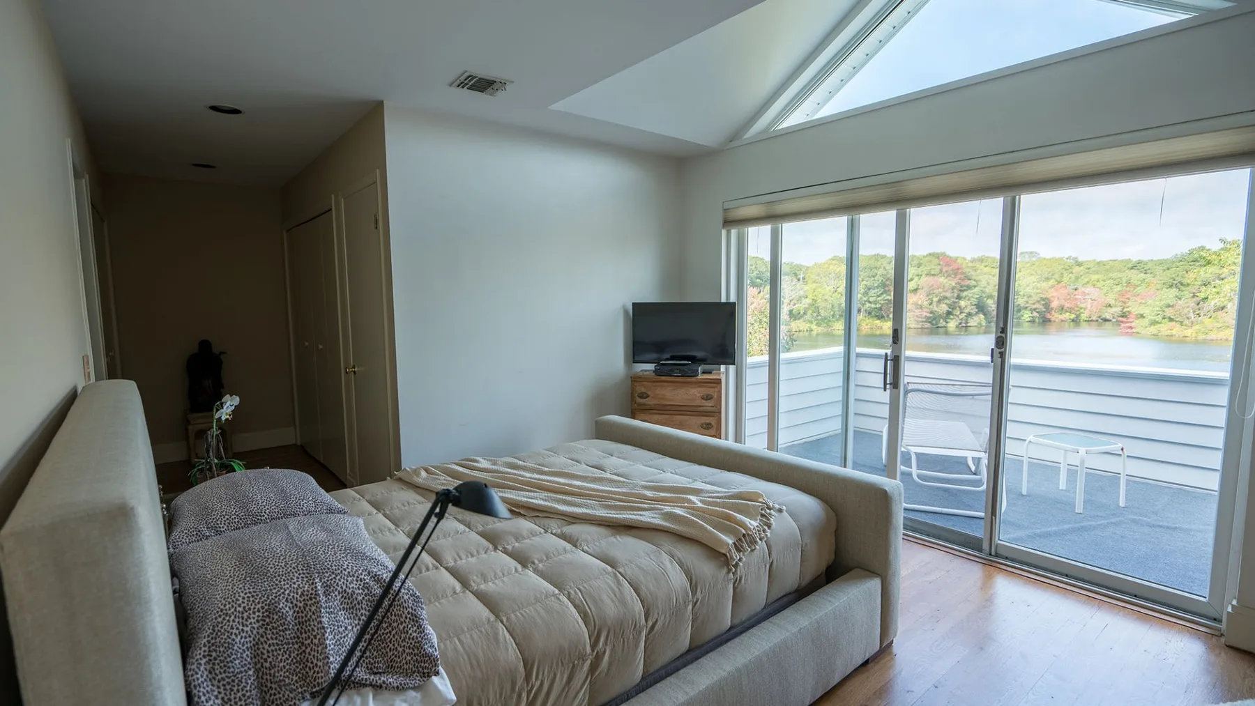 Un dormitorio con una cama junto a puertas corredizas de vidrio que dan a un balcón.