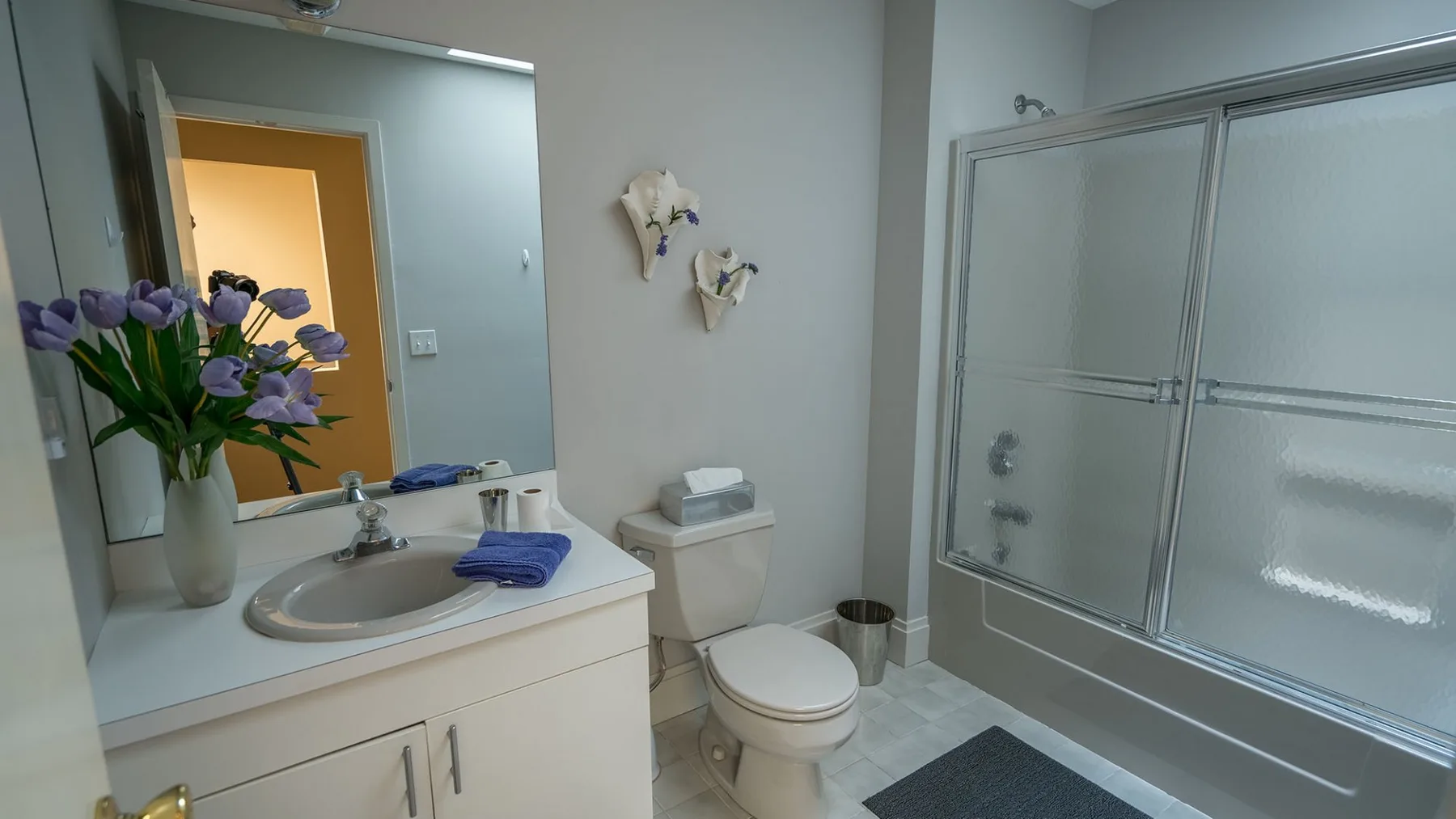 Se ven un tocador de baño, un lavabo, un inodoro y una bañera con ducha.
