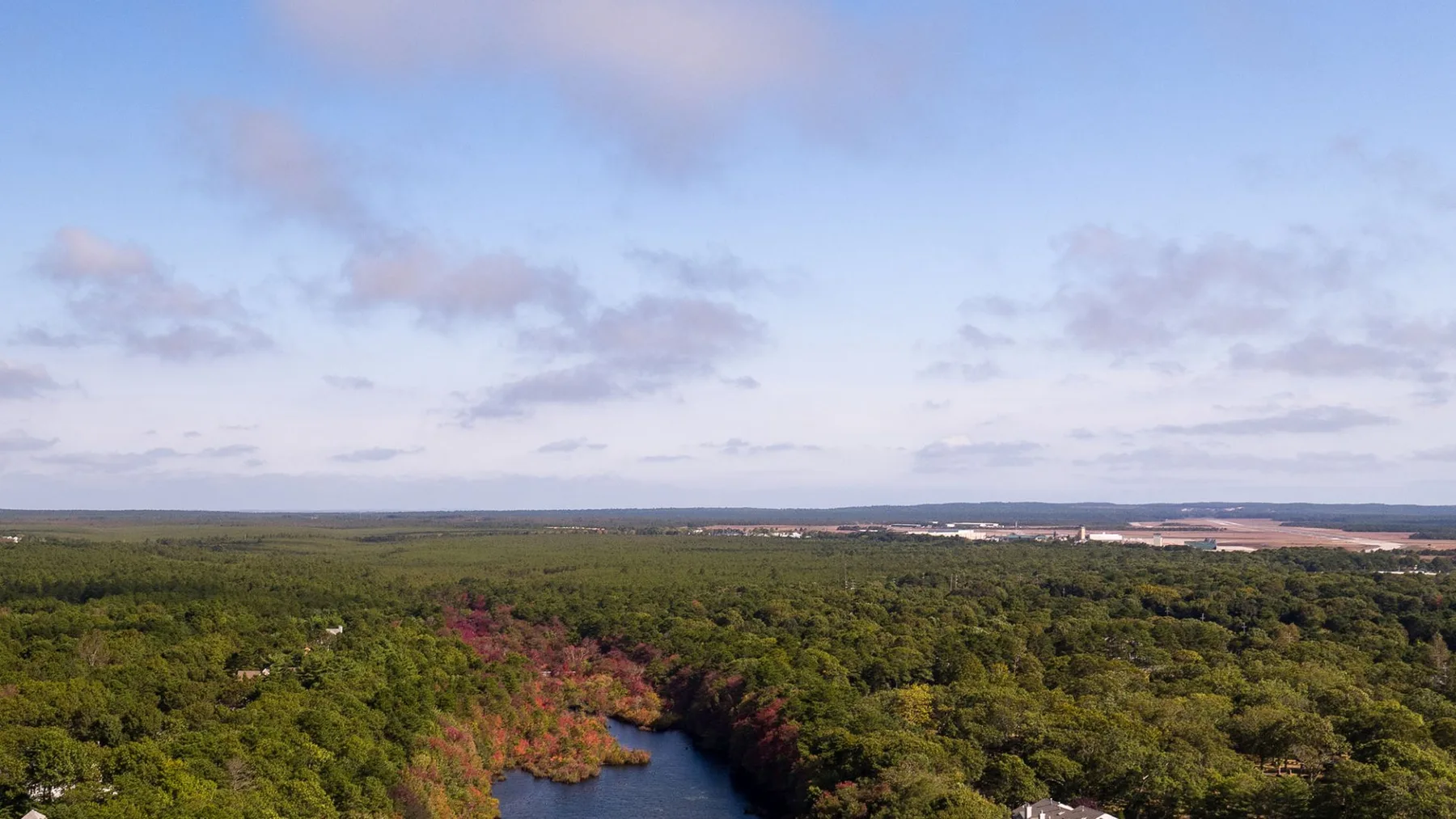 Vista aérea de un amplio paisaje boscoso bajo un cielo nublado.