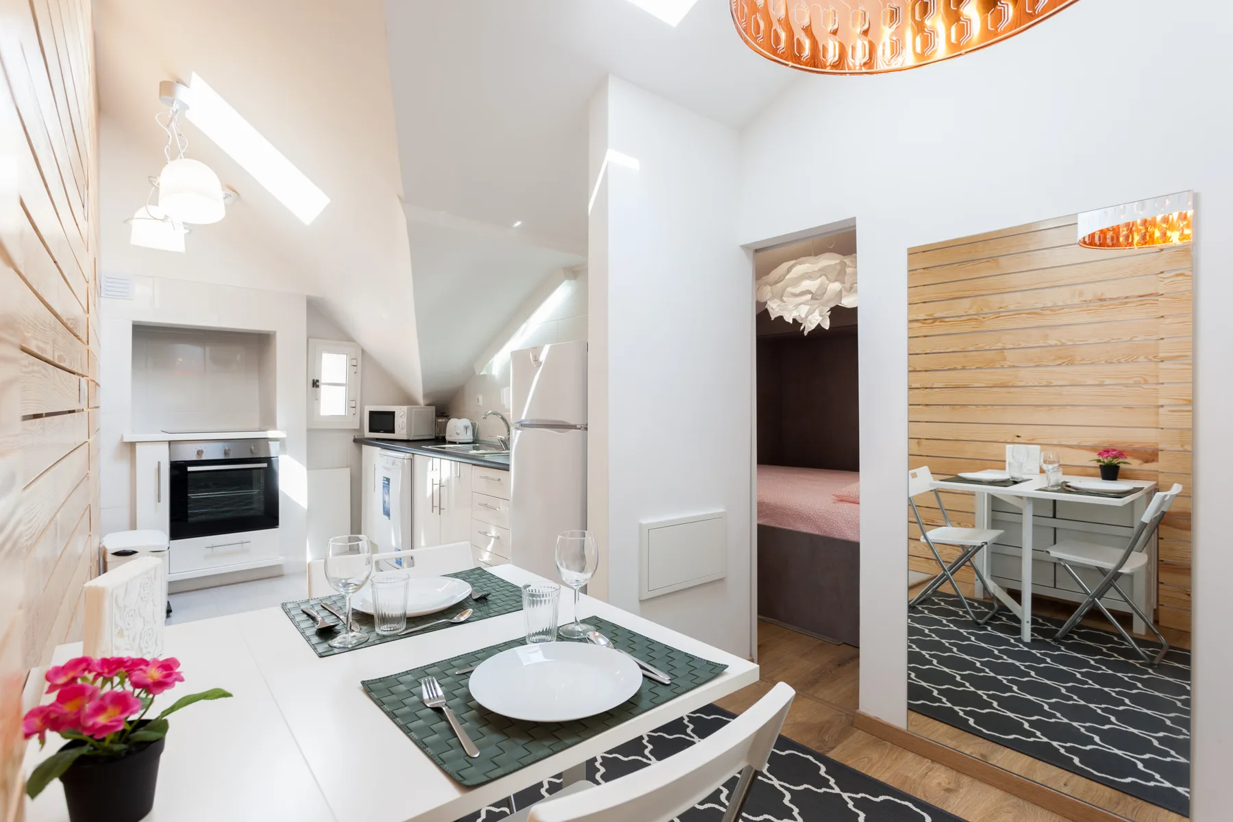 A bright kitchen and dining area with a table set beside the cooking area.