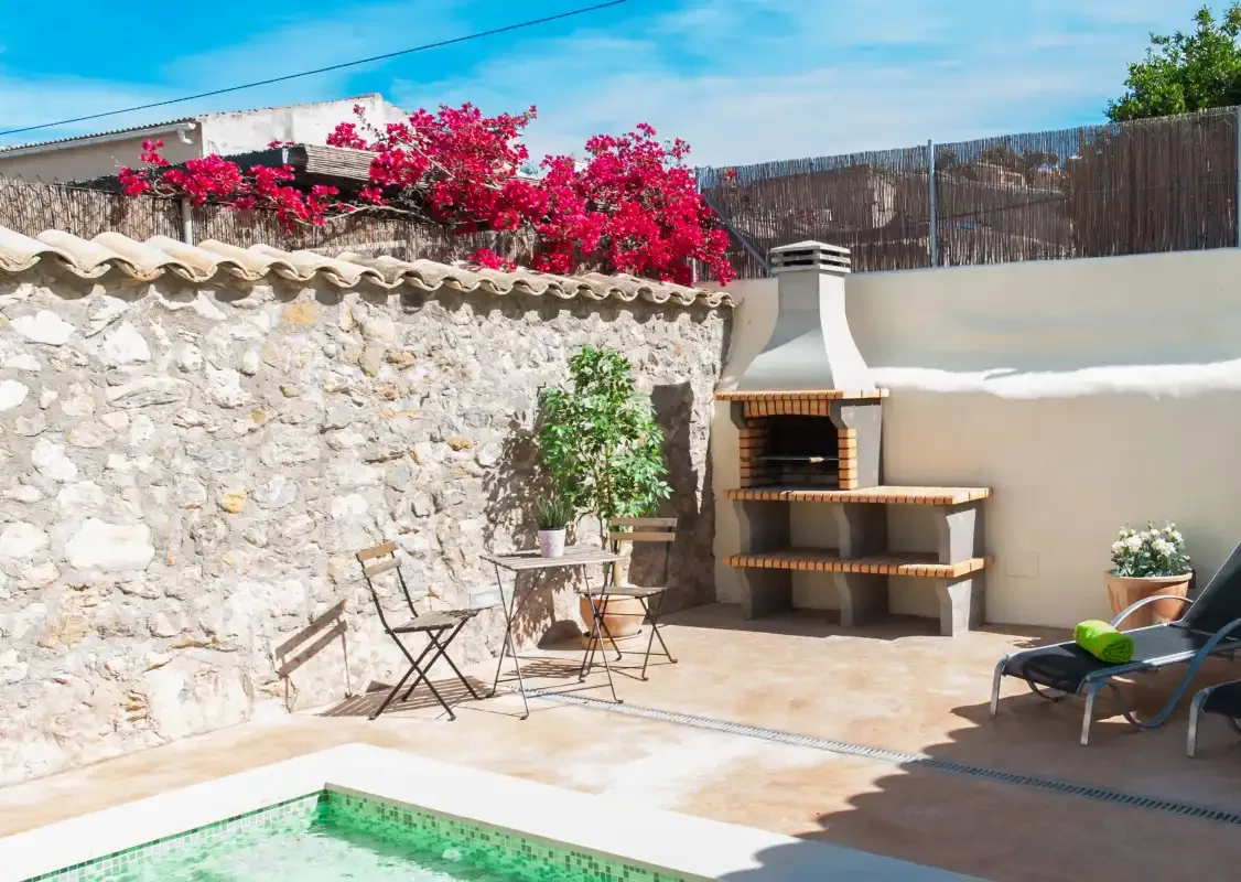 Outdoor patio with a small pool, seating, and a built-in barbecue.