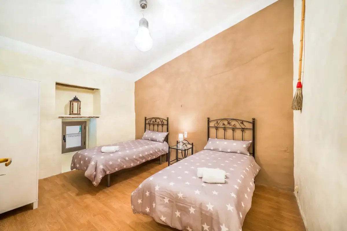 A bedroom with two beds dressed in patterned bedding.