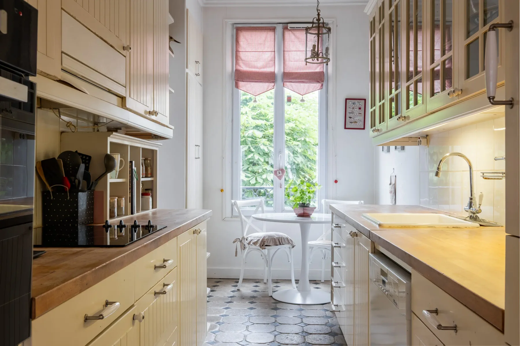Una cocina luminosa con gabinetes claros y una ventana con vista a la vegetación.