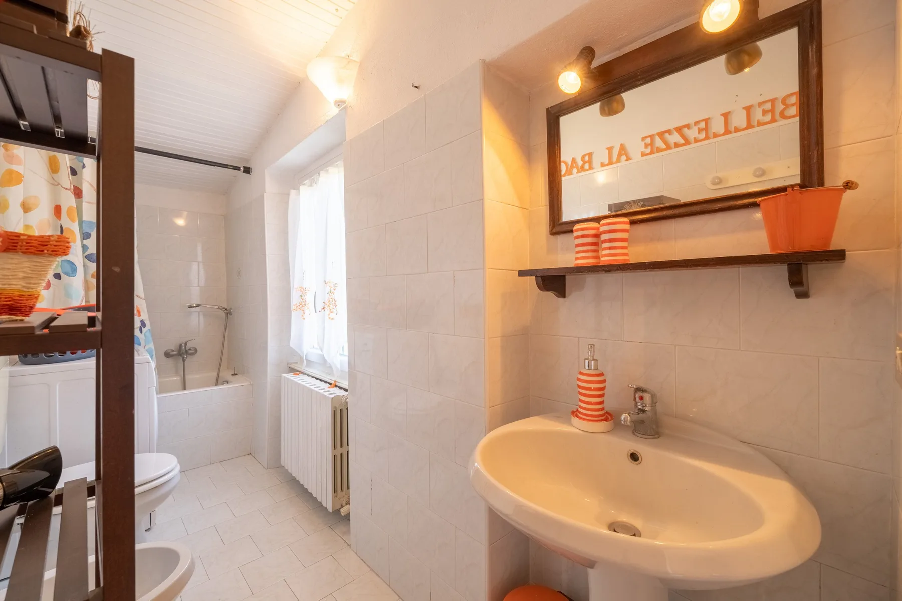 A tiled bathroom with a bathtub, shower, and sink beneath a mirror.