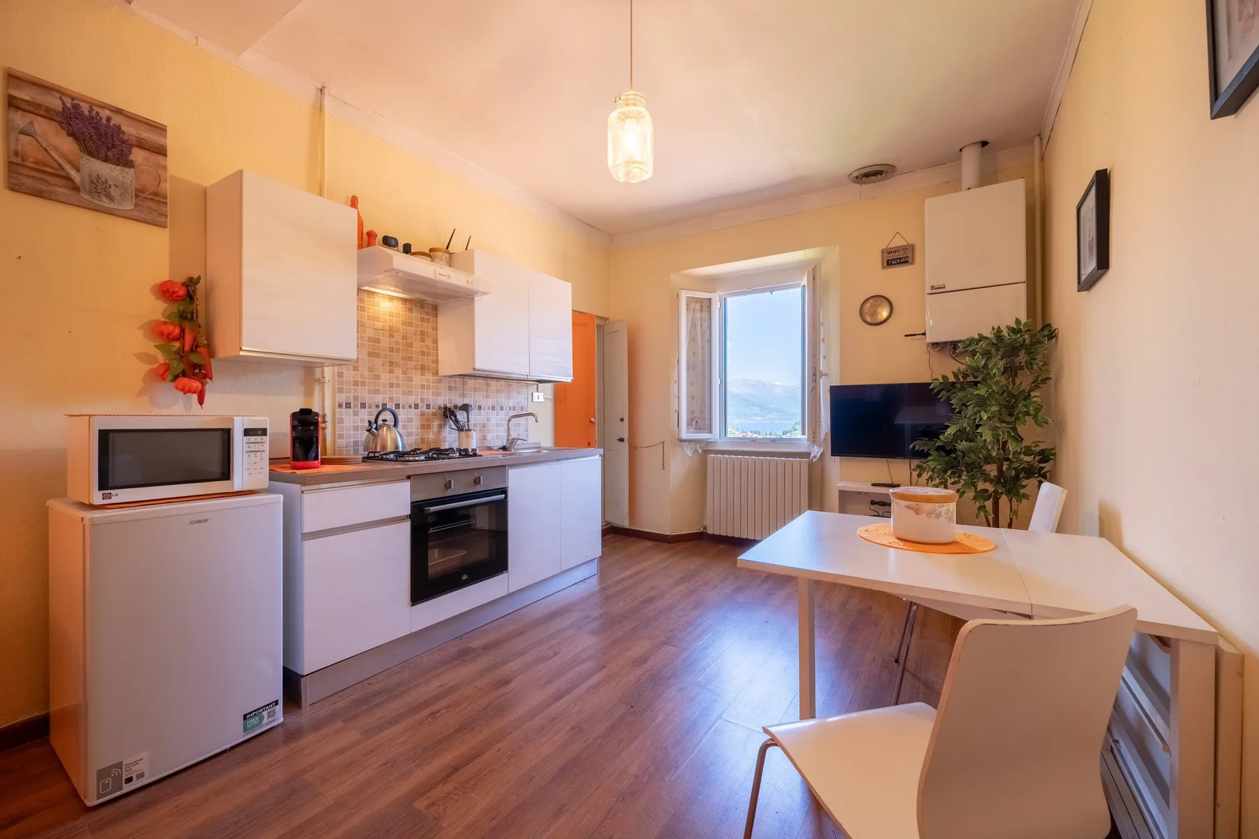 A compact kitchen and dining area with white cabinets, a table, and chairs.