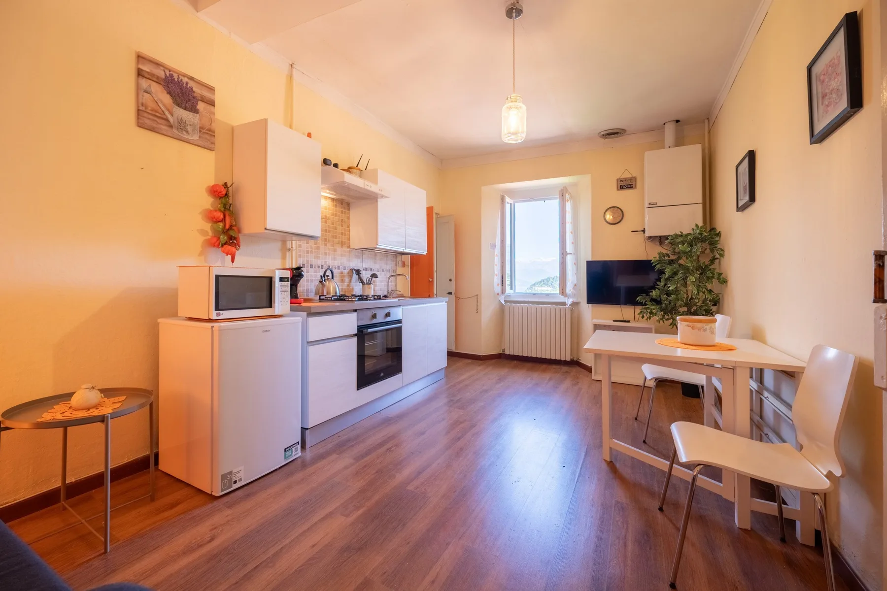 A compact kitchen and dining area with a table beside the window.