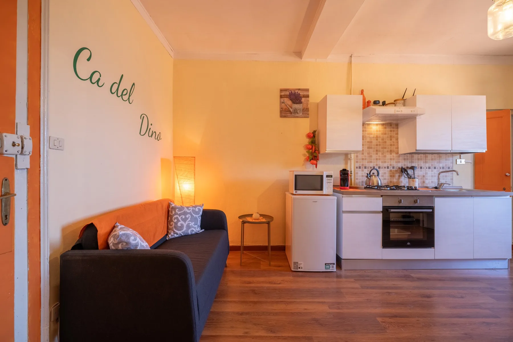 A living area with seating beside a compact kitchen.