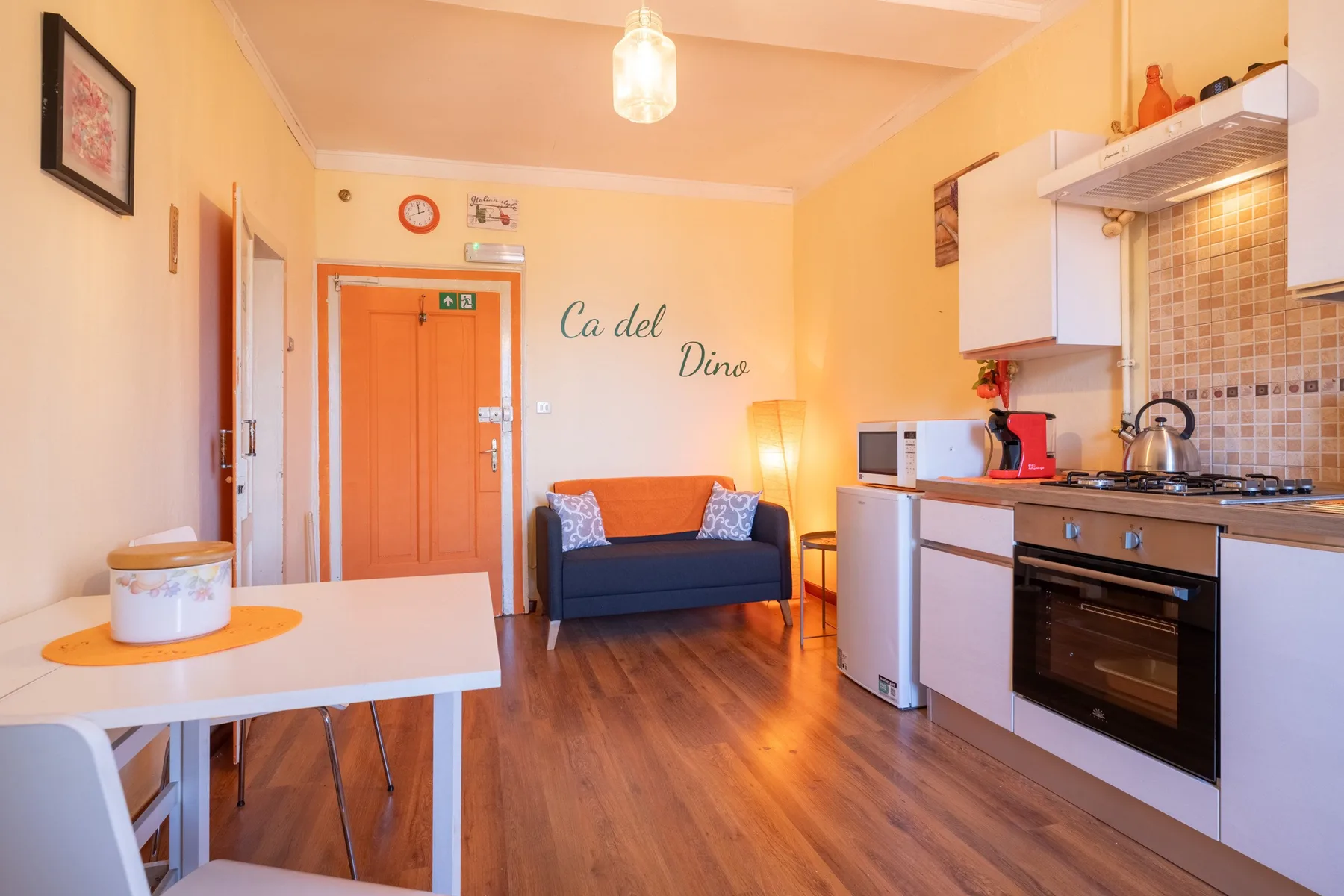 A combined living and kitchen area with a small dining table and sofa.