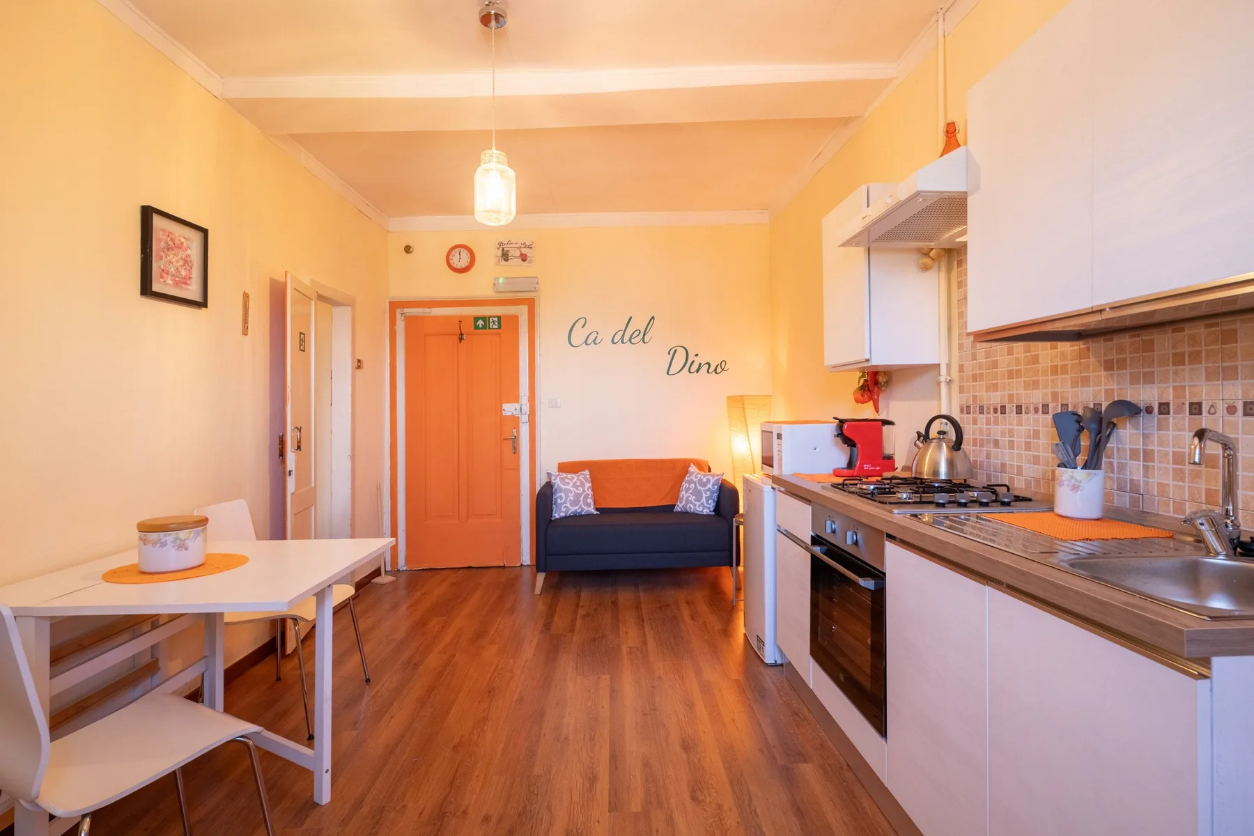 A compact kitchen and dining area opens onto a small seating space.