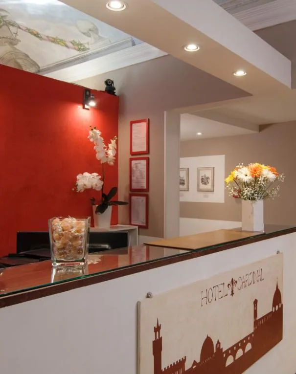 Recepción del hotel con decoraciones florales y obras de arte.
