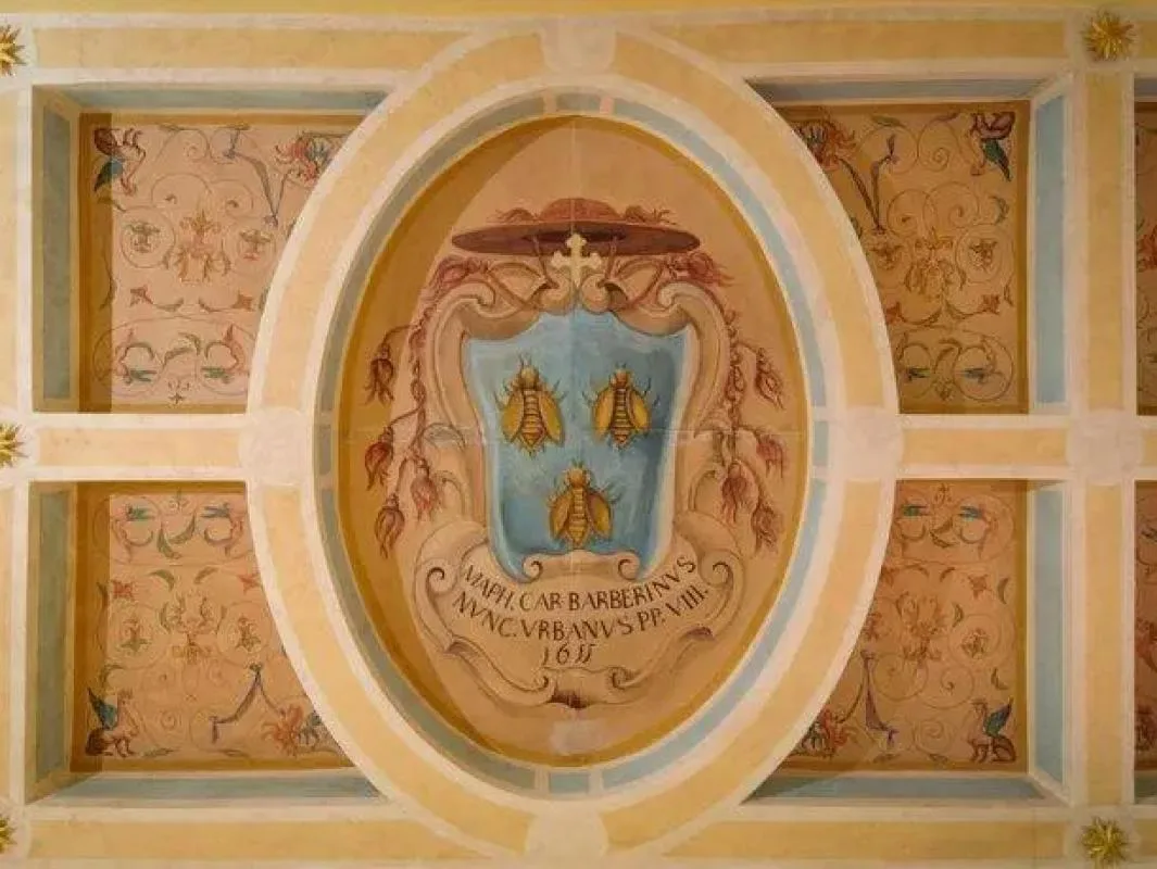 Fresco decorativo con un escudo de armas y abejas.