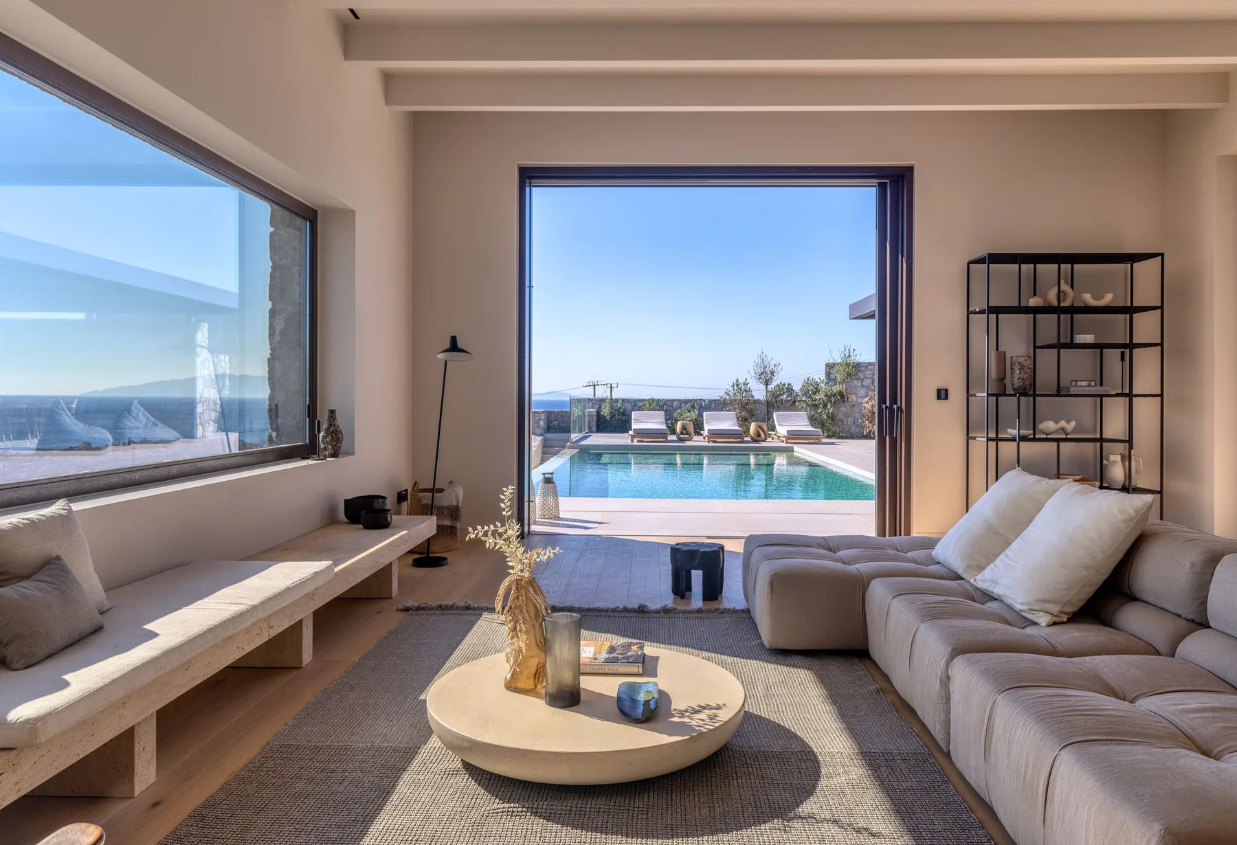 A living room opens onto a patio with a swimming pool.