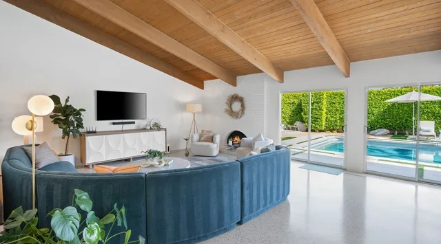 Una sala luminosa se abre a un patio con piscina y vegetación.