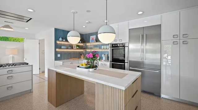 Una cocina moderna con una isla central y electrodomésticos de acero inoxidable.