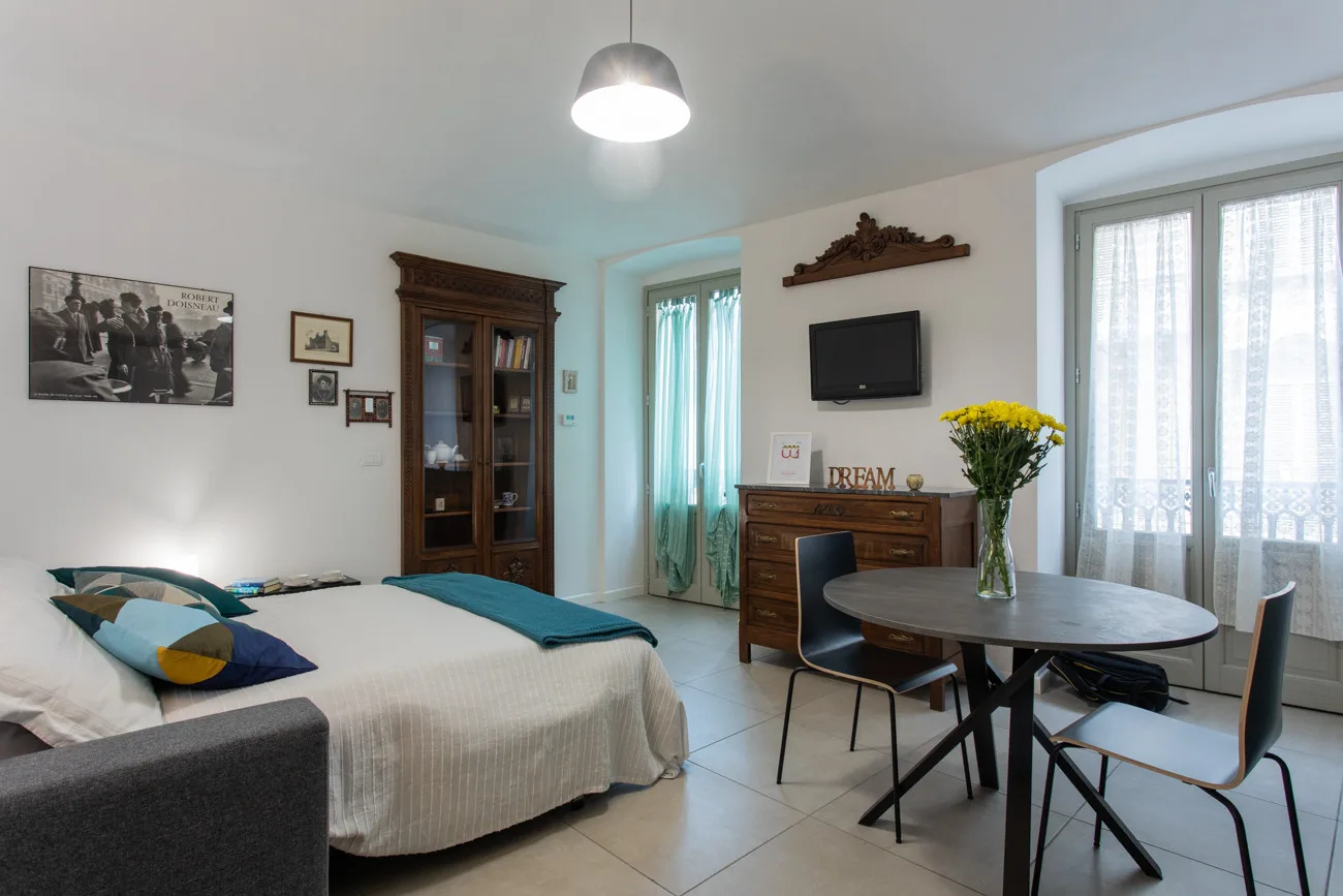 Un dormitorio con una cama, una mesa de comedor y un televisor.