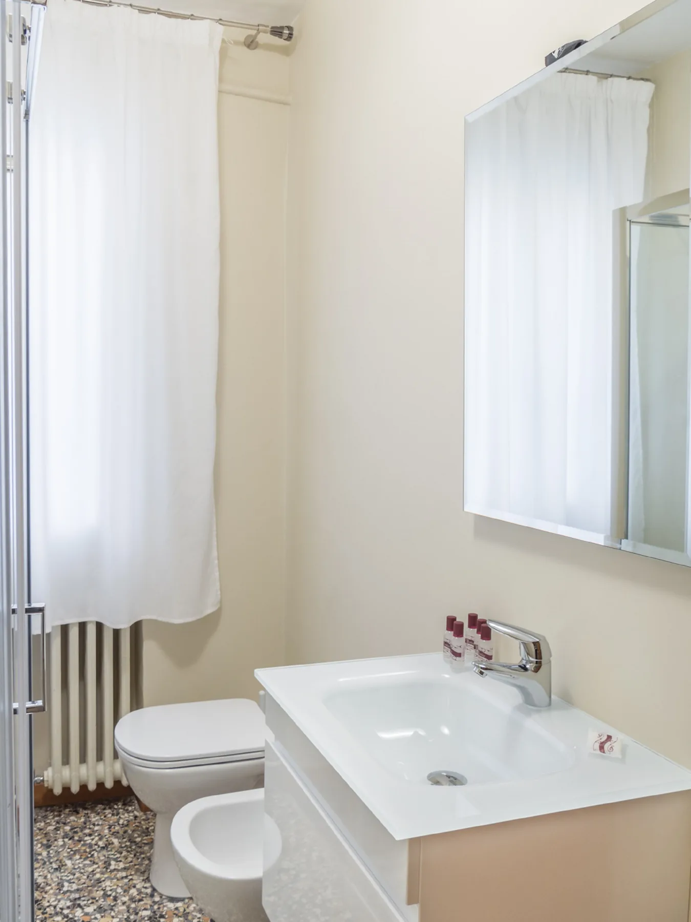 Un baño con lavabo, inodoro y cortina de ducha.