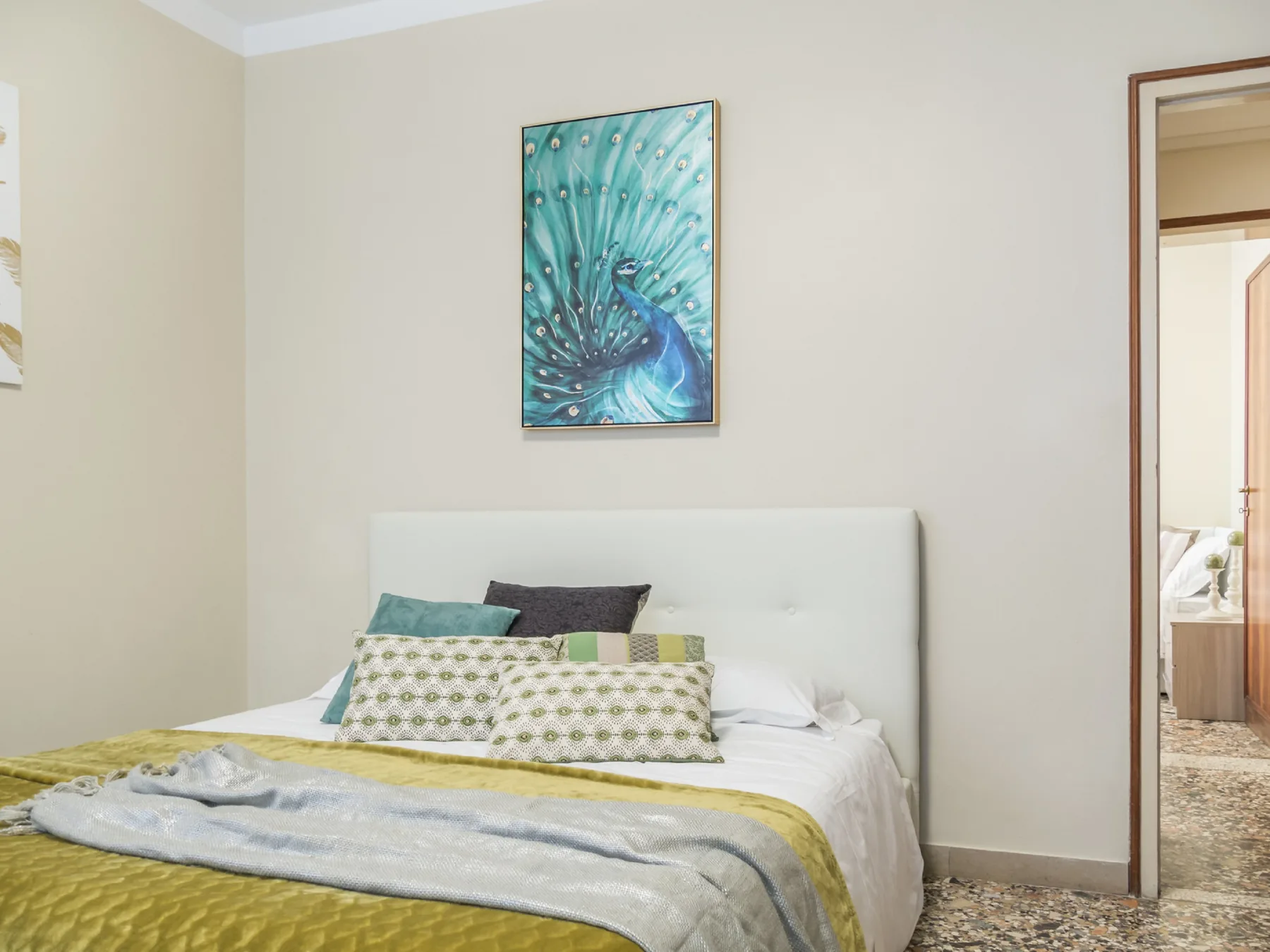 Un dormitorio con una cama cubierta de almohadas estampadas y mantas.