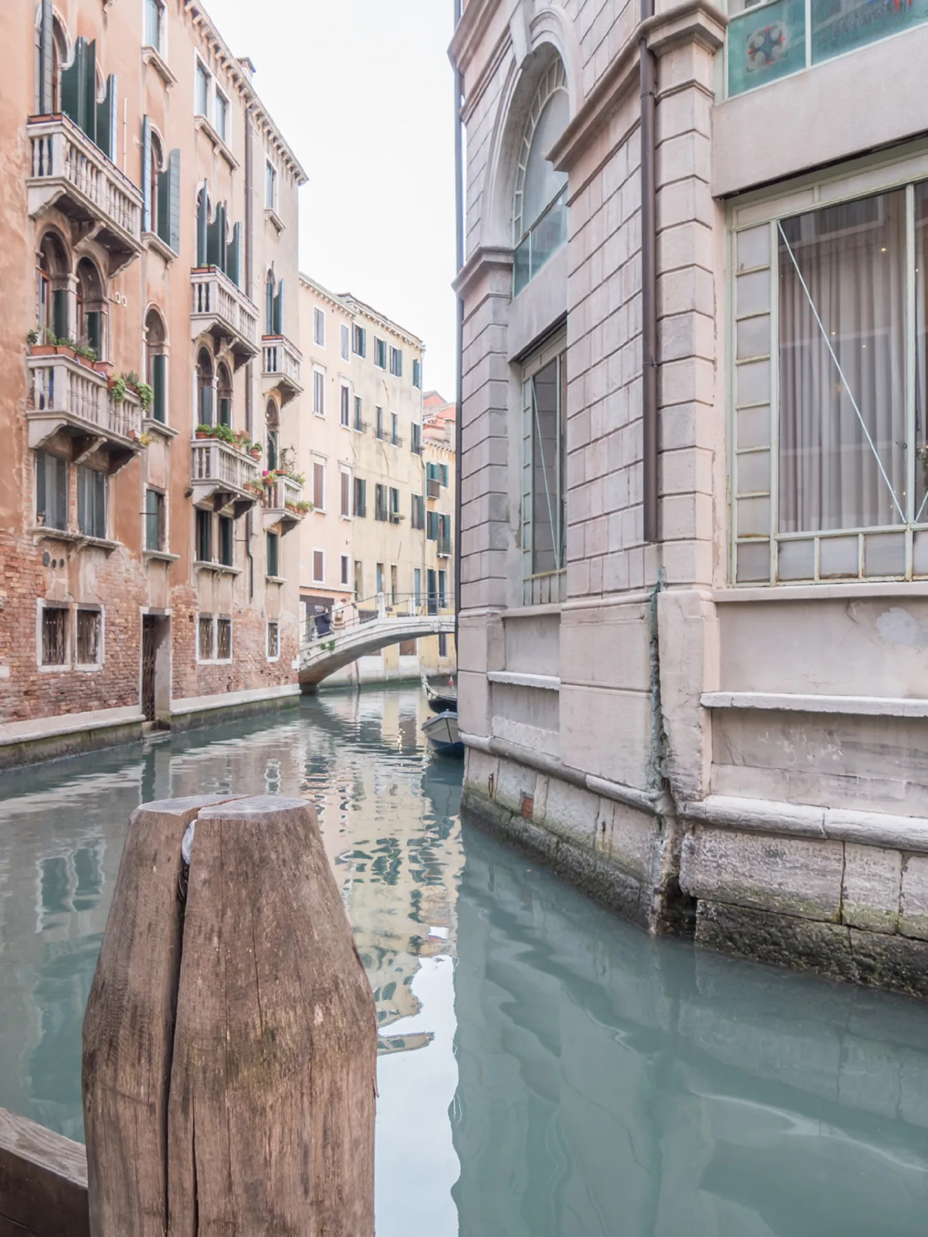 Un canal estrecho pasa entre edificios históricos, con un pequeño puente peatonal al fondo.