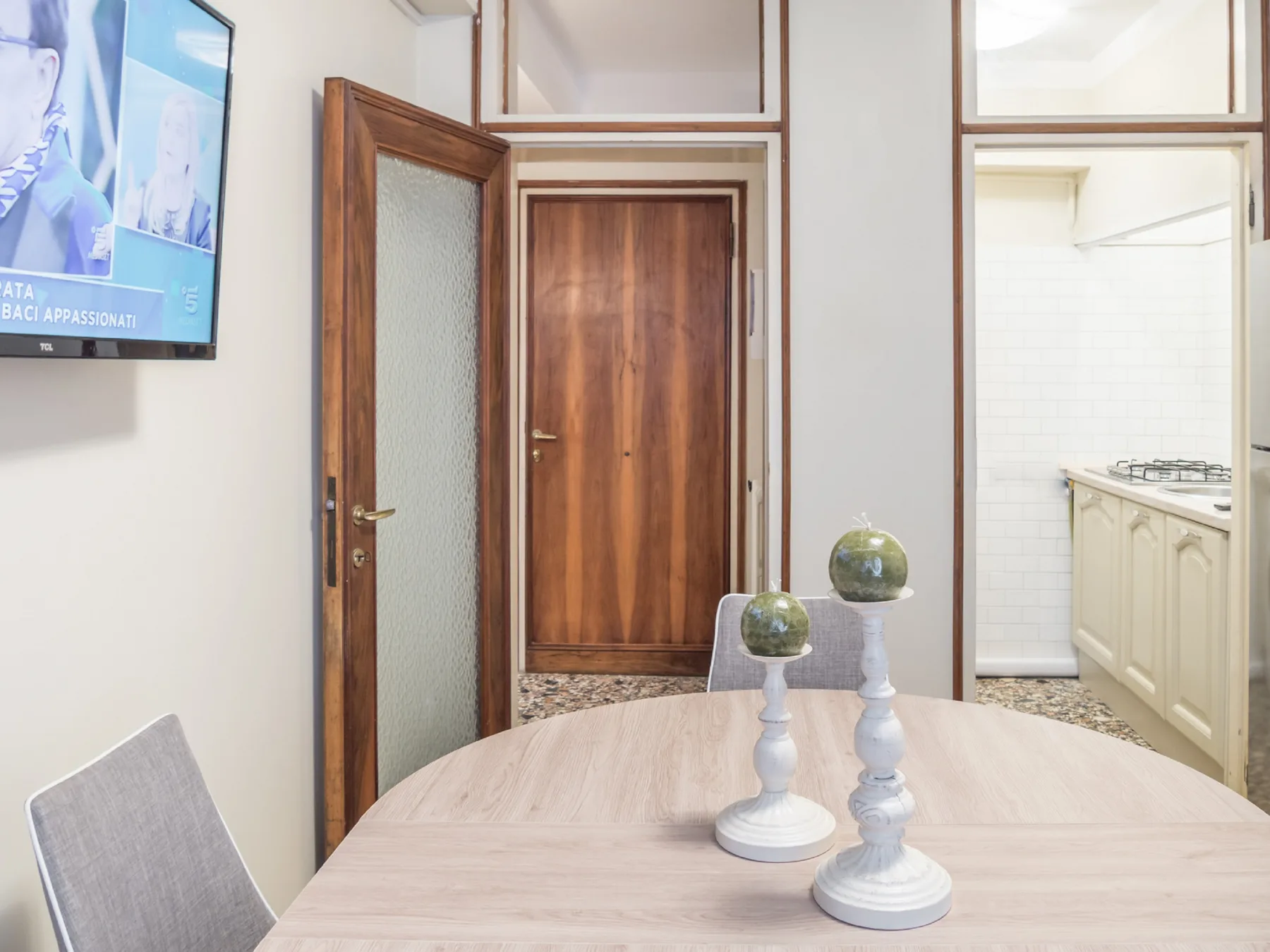 Un comedor con una mesa clara y portavelas decorativos.