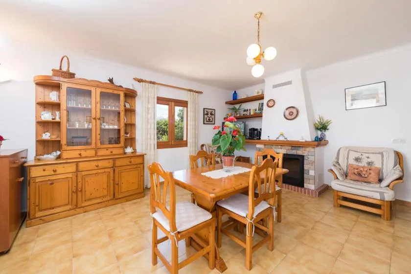 Comedor con una mesa y sillas de madera junto a una chimenea.