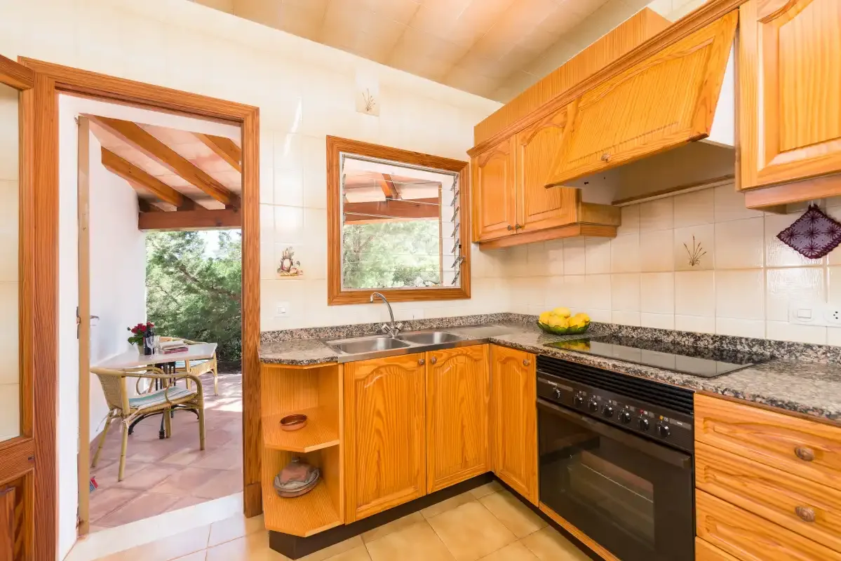 Una cocina con armarios de madera, una encimera y un horno integrado.