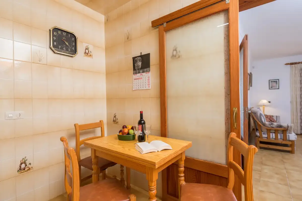 Un comedor con una mesa de madera y un libro abierto.