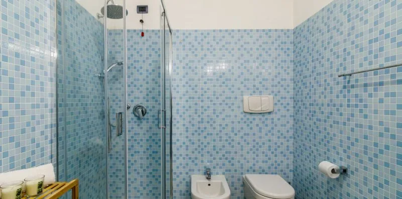 A tiled bathroom with a shower, sink, and toilet.