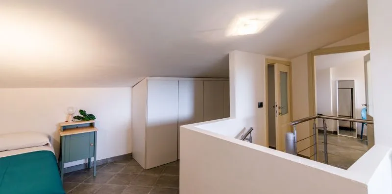 A bright room with a low ceiling, built-in cabinets, and a half-height partition.