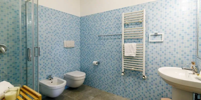 A tiled bathroom with a shower, toilet, and sink.