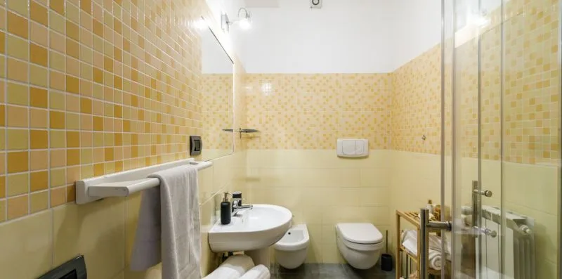 A tiled bathroom with a sink, toilet, and glass shower.