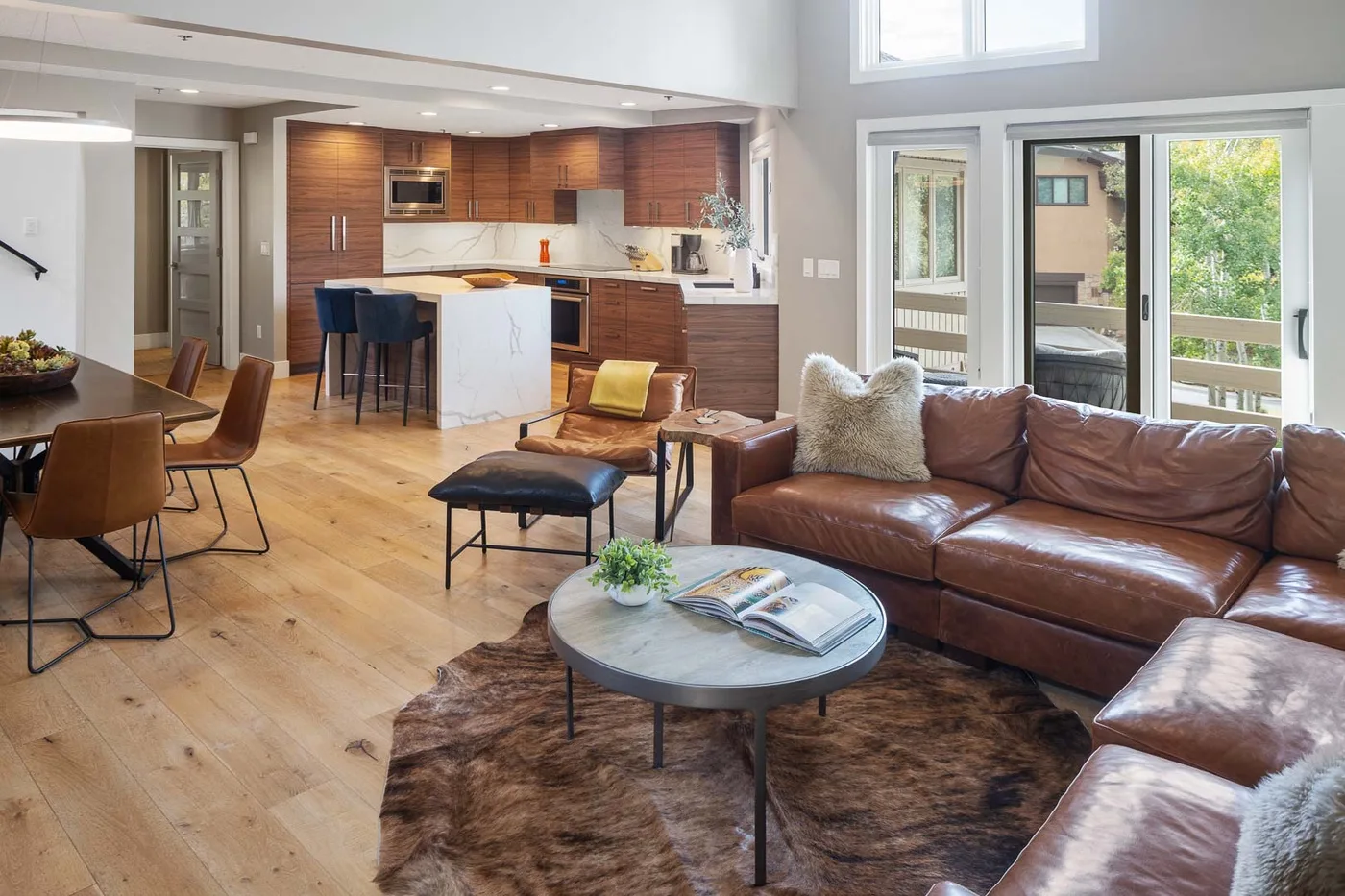 Open-plan living room with seating area, dining table, and kitchen.