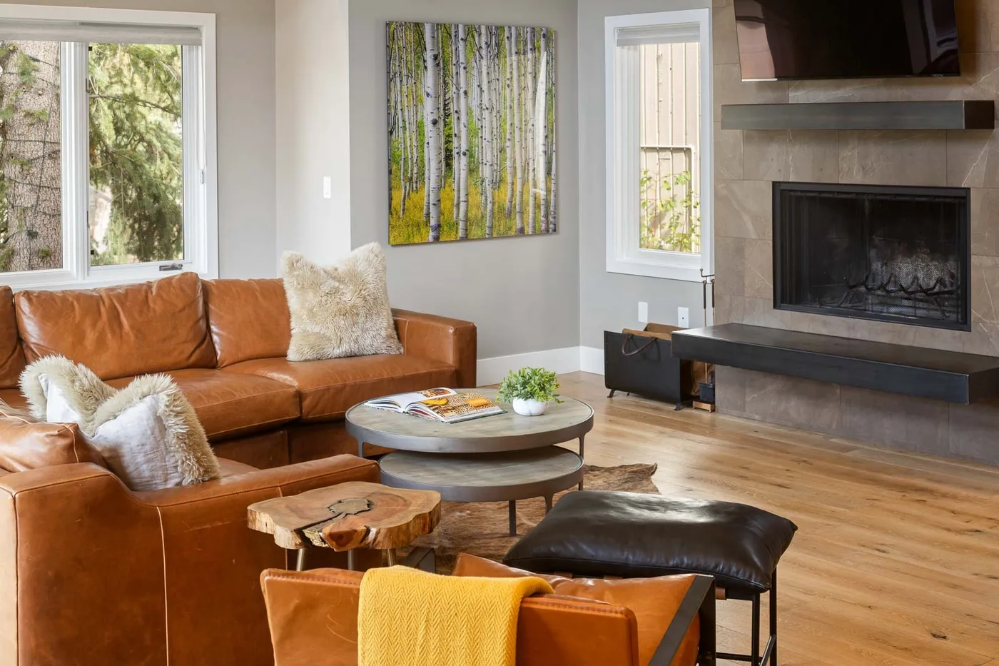 A living room with leather seating, a coffee table, and a fireplace.