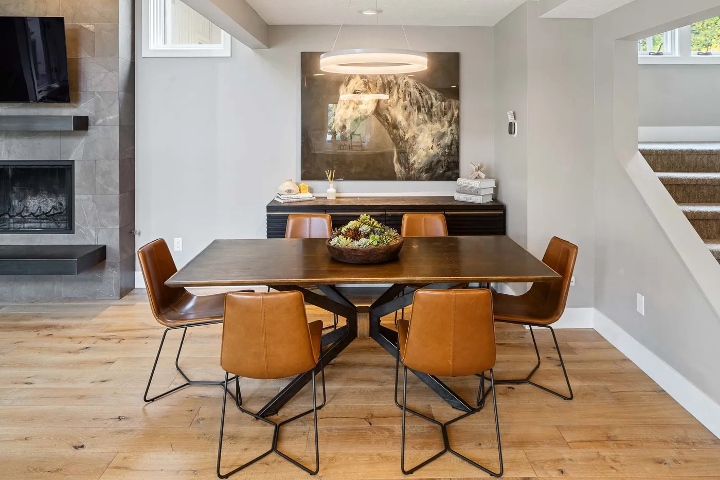 A dining area with a table and chairs beside a fireplace.