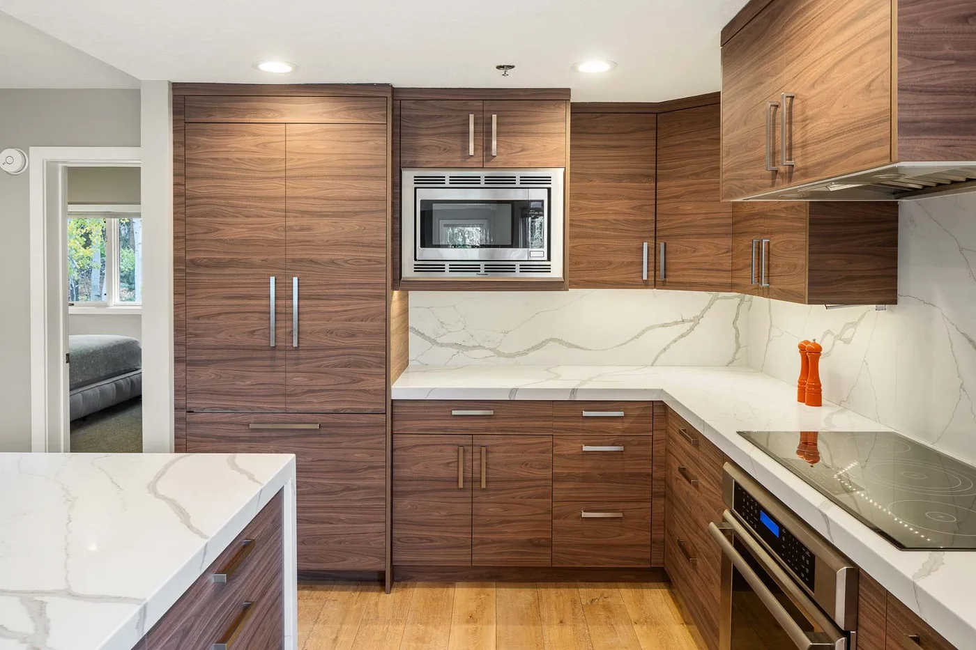 A modern kitchen with wood cabinetry, a countertop, and built-in appliances.