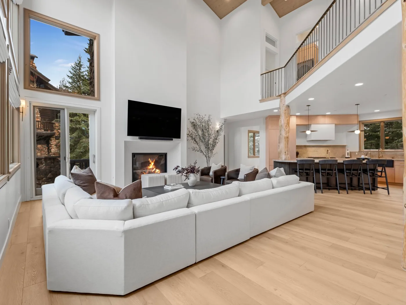 A bright open-plan living room and kitchen with a large sectional seating area.
