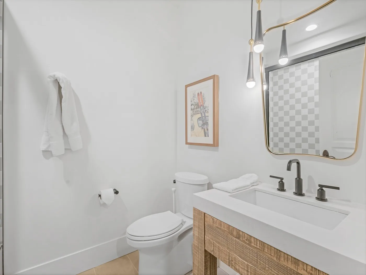 A bright bathroom with a vanity, mirror, and toilet.