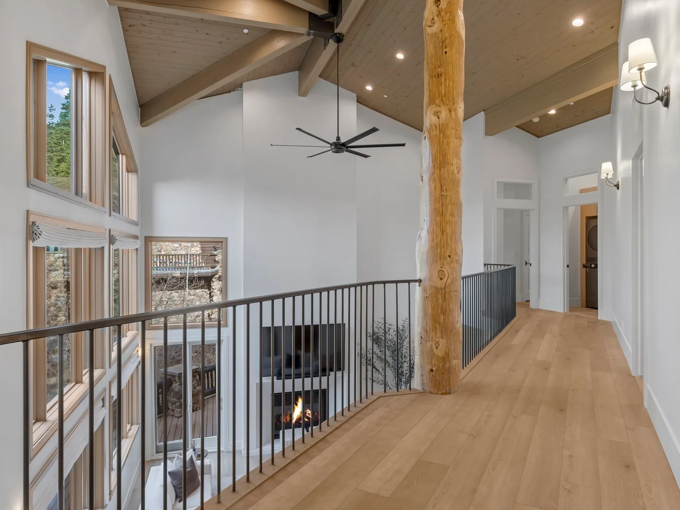 A wood-floored upper hallway overlooks a living area below.