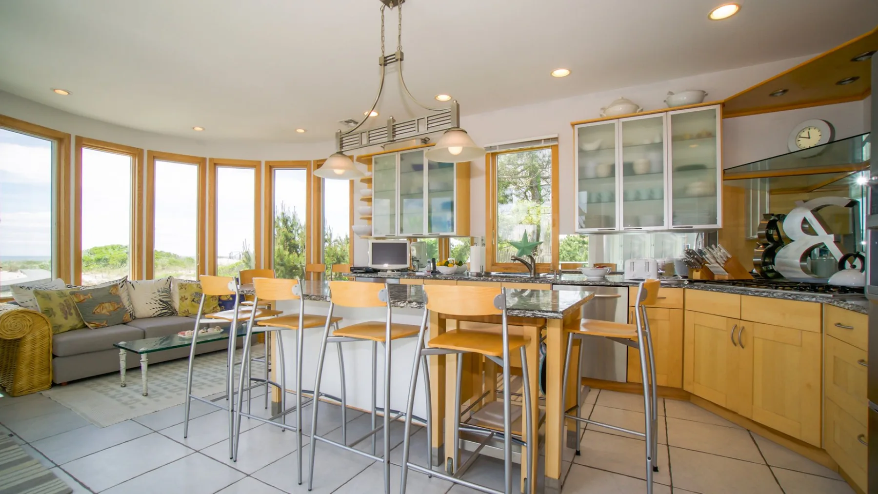 A bright kitchen and dining area with a central island and large windows.