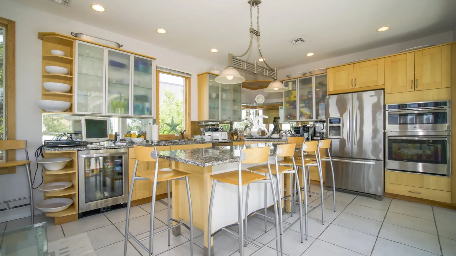Una cocina luminosa con una isla central y gabinetes de madera clara.