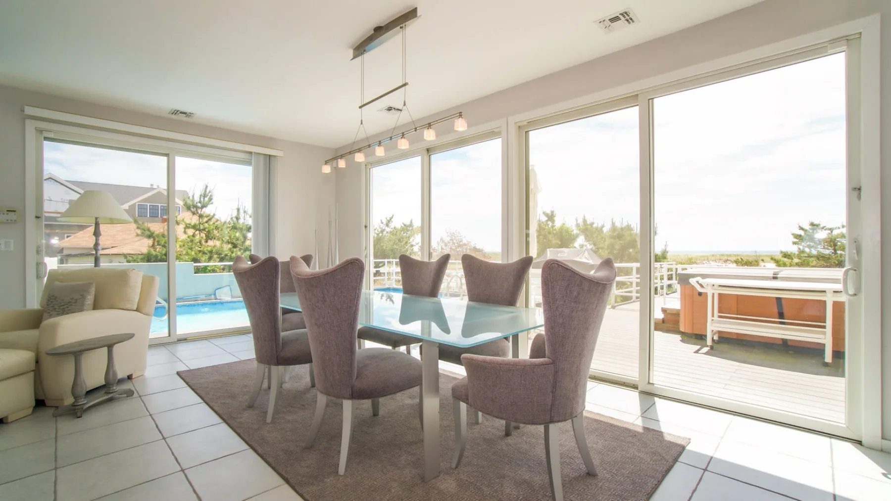 Un comedor luminoso se abre a un patio a través de grandes puertas de vidrio.