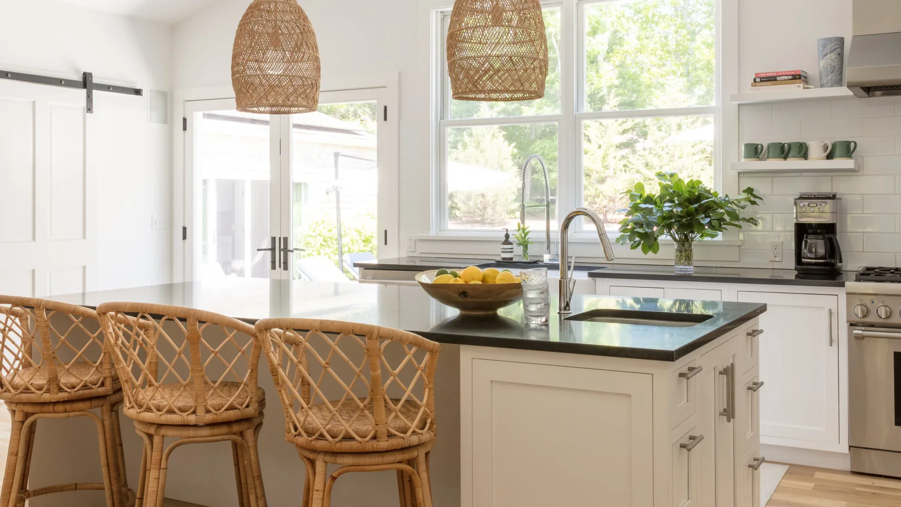 Una cocina luminosa con una isla central y grandes ventanas.