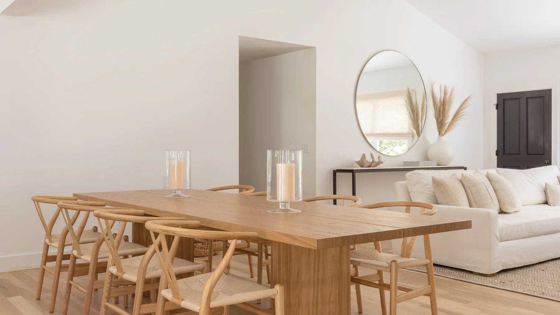 Un comedor con una mesa de madera y sillas junto a una sala de estar.